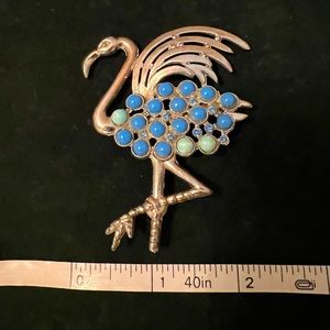 Playful flamingo brooch with opaque blue accent stones